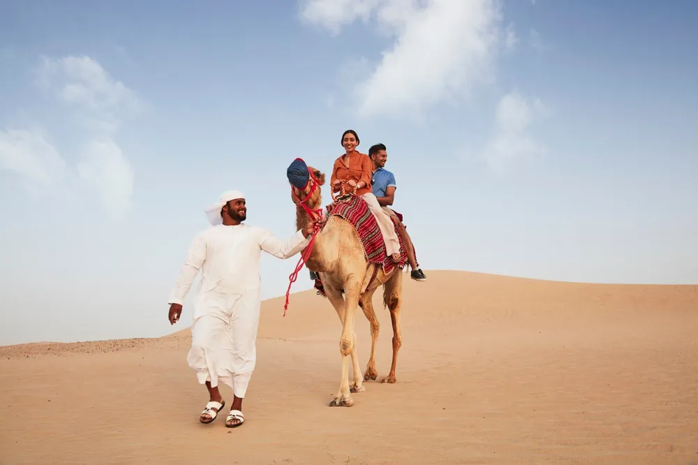 Caravane de chameaux avec un guide dans le désert